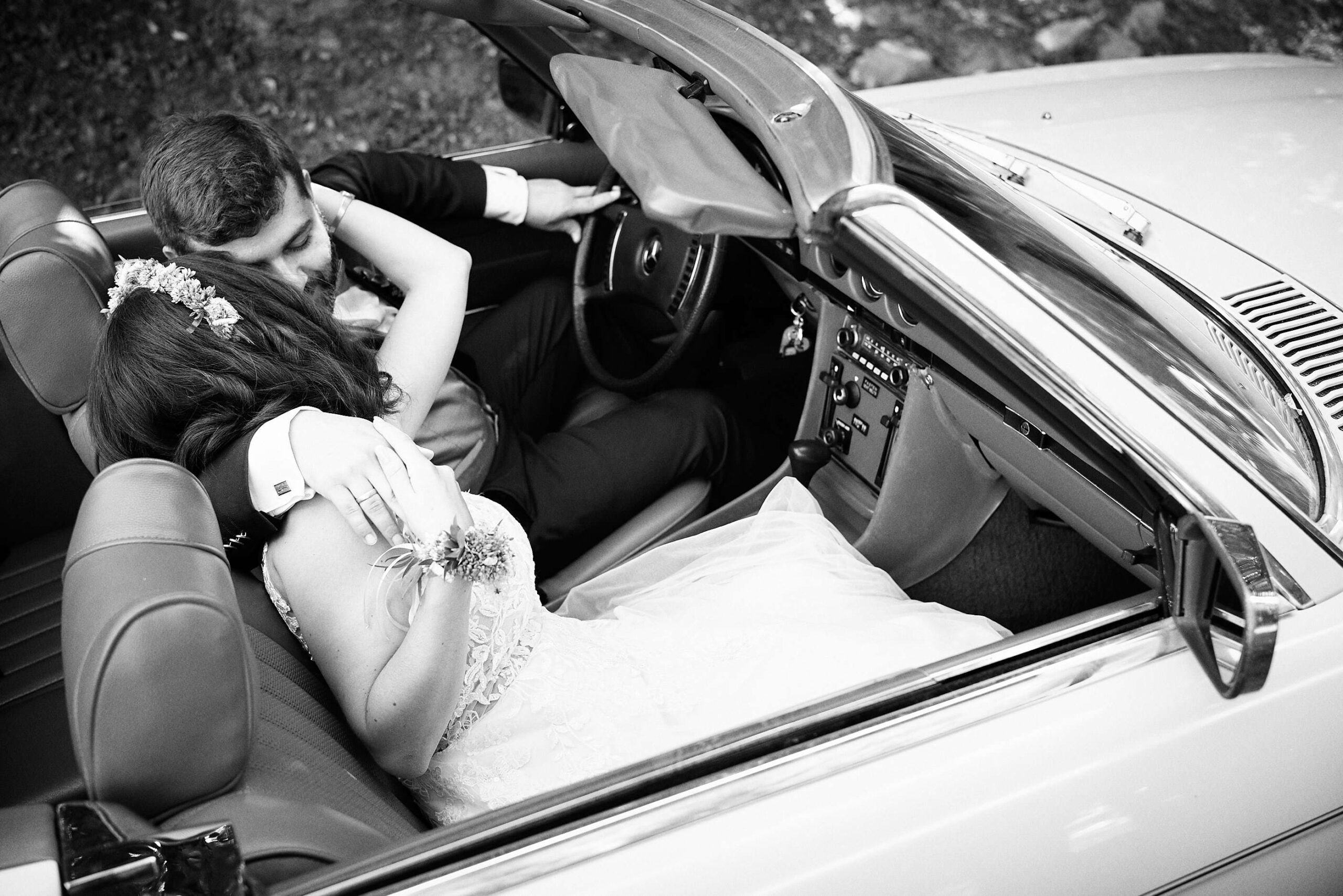 Onelovephoto Hochzeitsfotografie aus Mannheim. Eine Braut und ein Bräutigam verbringen während eines After-Wedding-Shootings einen intimen Moment auf dem Rücksitz eines Cabriolets. Lebendige Hochzeitsreportagen für jedes Budget.