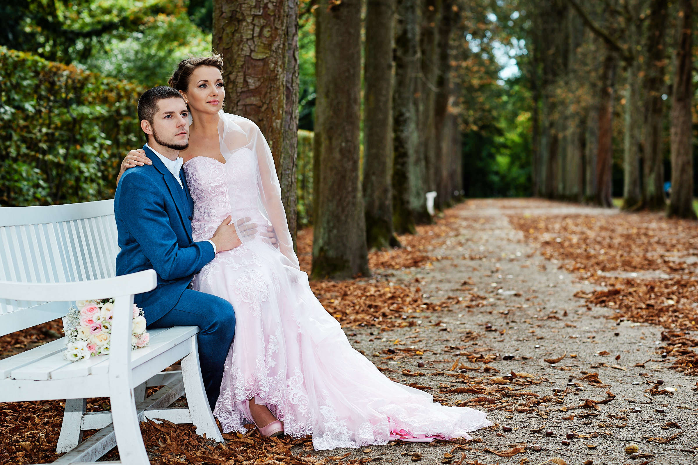 After-Wedding. Die Braut mit einem zart rosa farbigen Kleid schaut in den Park.